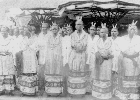 A black and white photograph of a large group of women warriors in Dahomey wearing decorative horns 